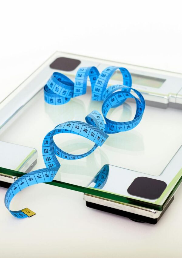blue tape measuring on clear glass square weighing scale