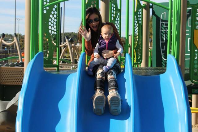 Mom and baby on slide for the first time at a park