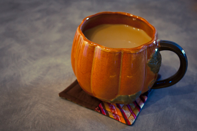Studies have shown that coffee tastes better when served in a pumpkin shape cup on top of a hand made coaster.