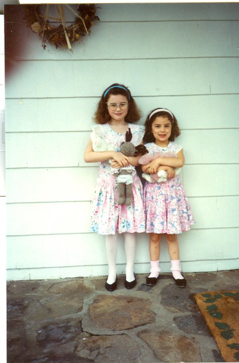 little girls in matching dresses holding stuffed animals