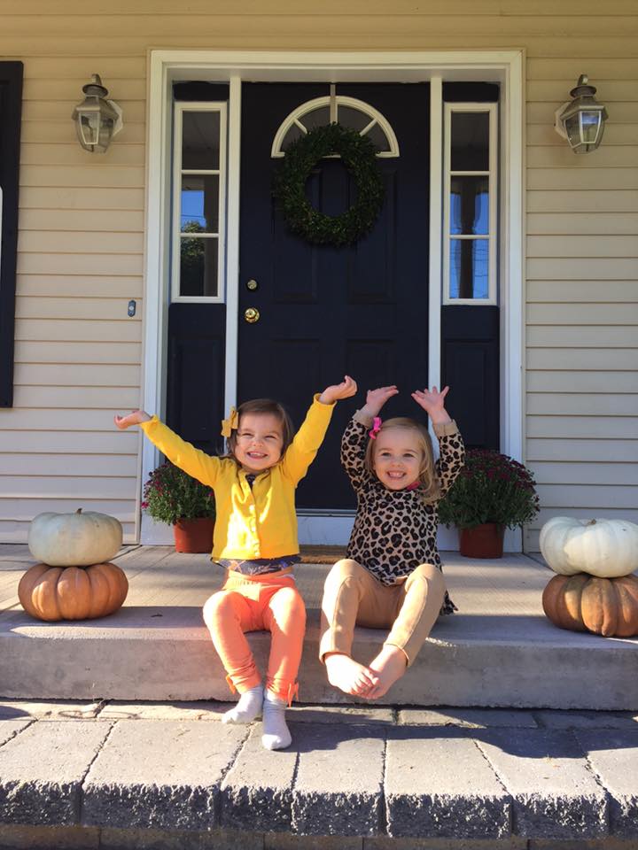 Little Girls With Arms in Air Smiling on Front Porch