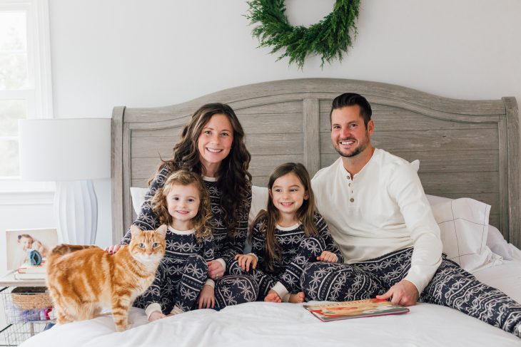 Family in Matching Pajamas for Christmas or Winter Photos Sitting on Bed