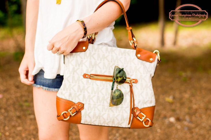white leather micheal kors bag with sunglasses woman in jean shorts and white shirt