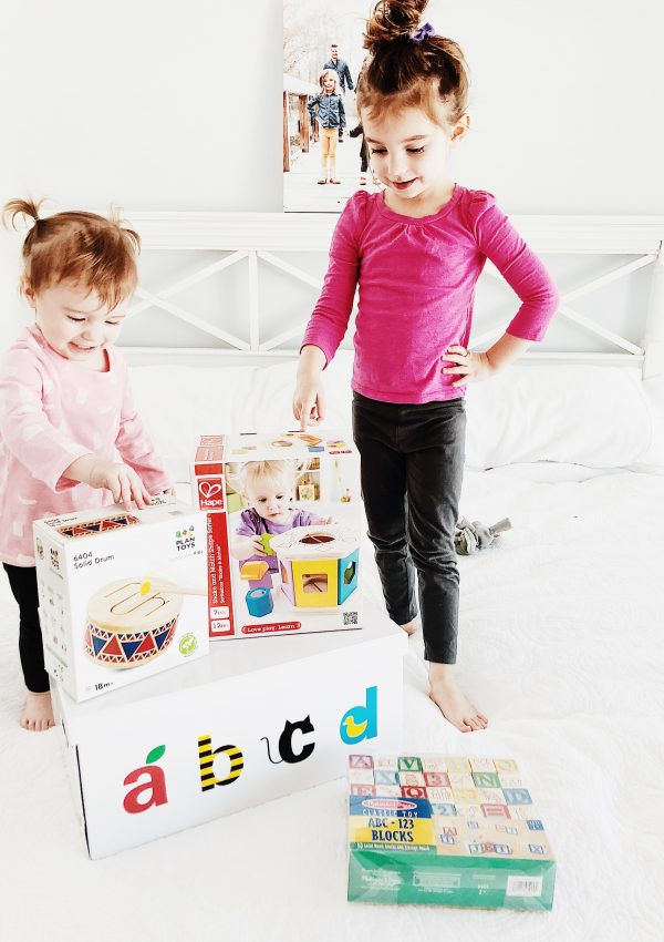 Happy kids sitting on bed with abcd box