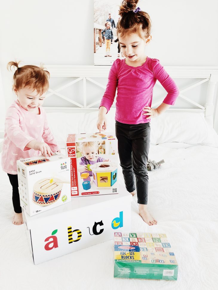 Happy kids sitting on bed with abcd box 