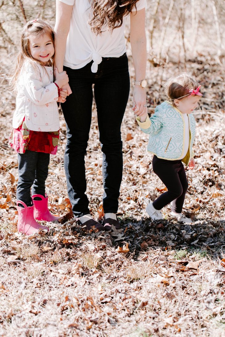 Little girls standing beside Mom's legs