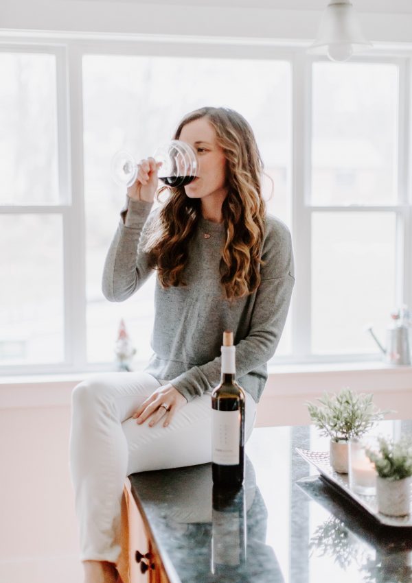 Woman drinking wine on counter