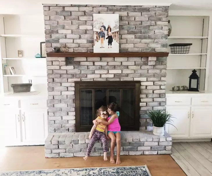 kids sitting on whitewash fireplace 