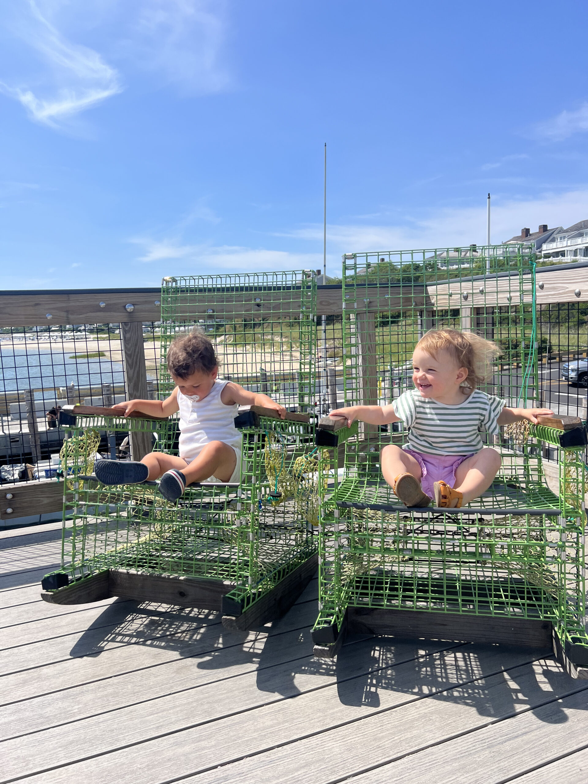 Babies sitting on lobster pot rocking chair Chatham fishing pier