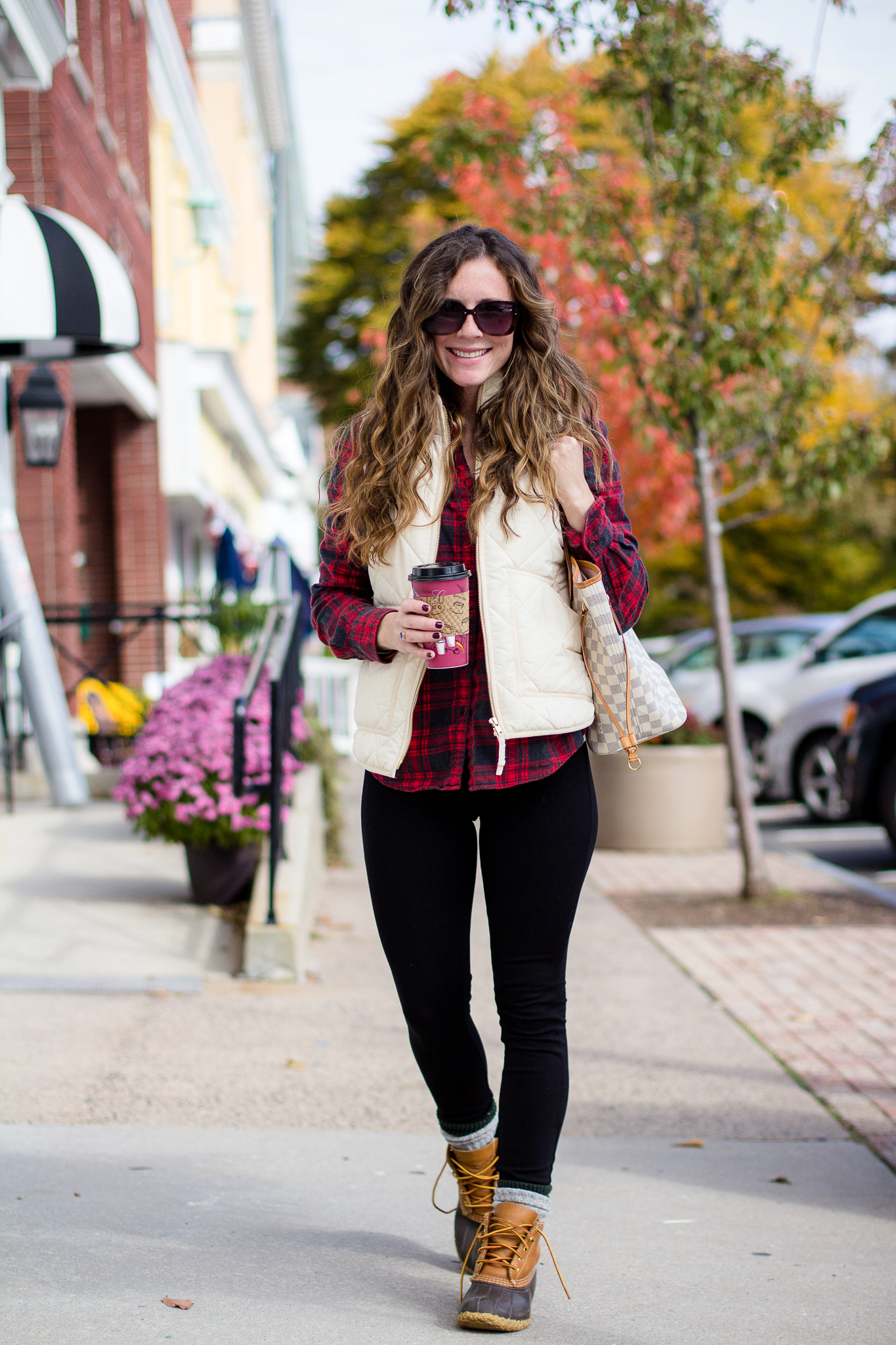 Woman with red and black jcrew flannel and white puffer vest