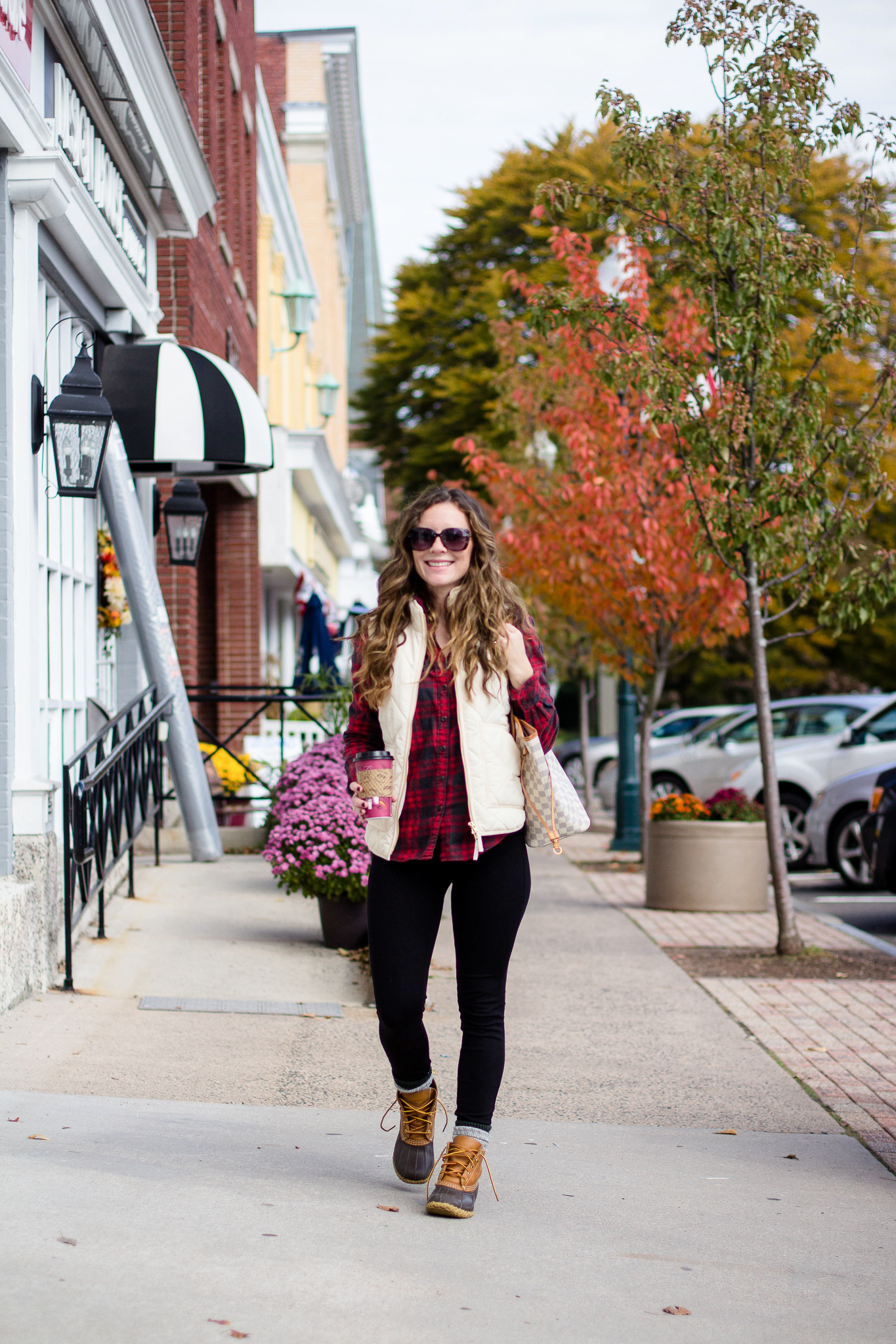Woman with red and black jcrew flannel and white puffer vest