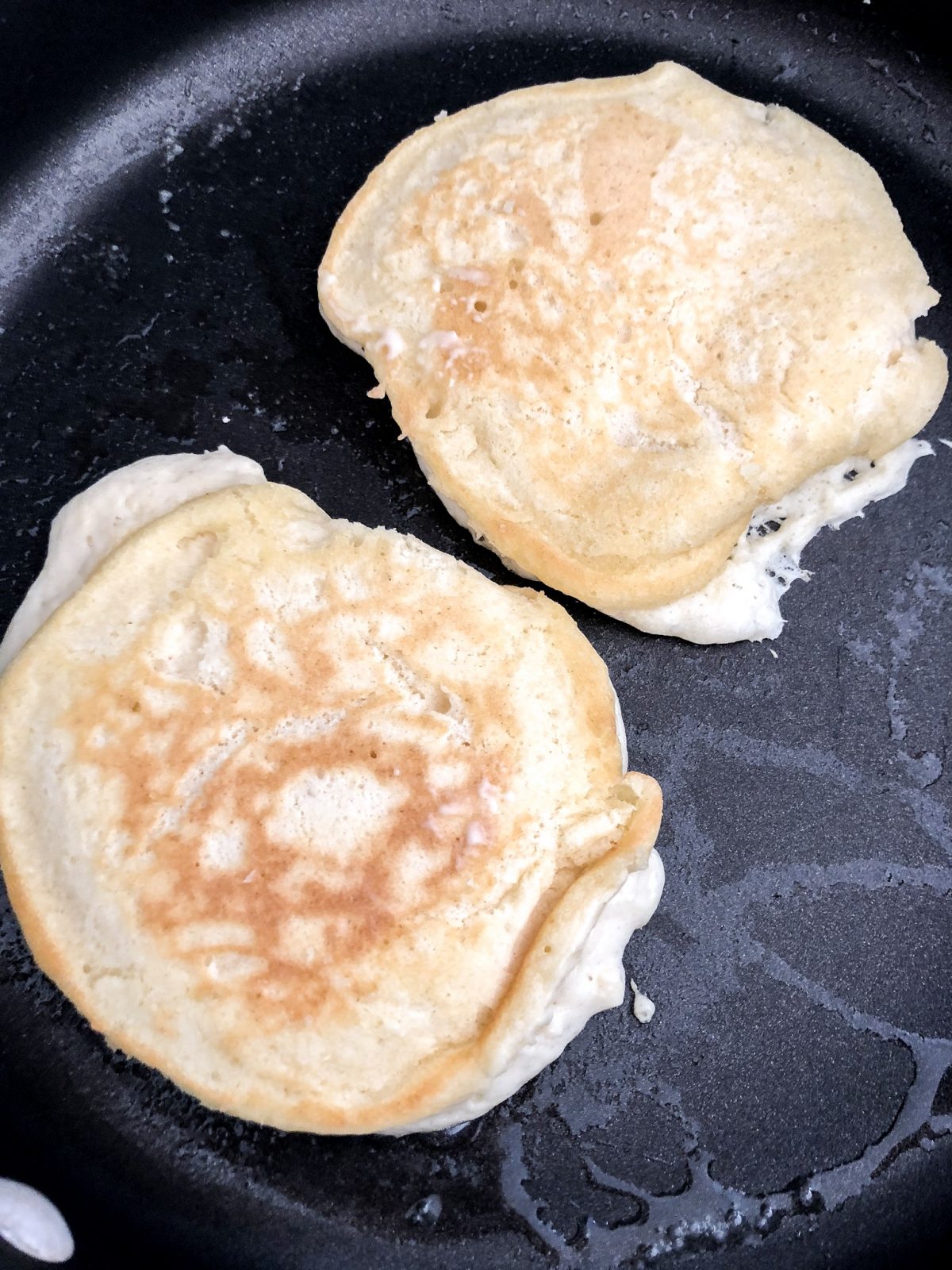 fluffy Pancakes on a buttered Skillet cooking