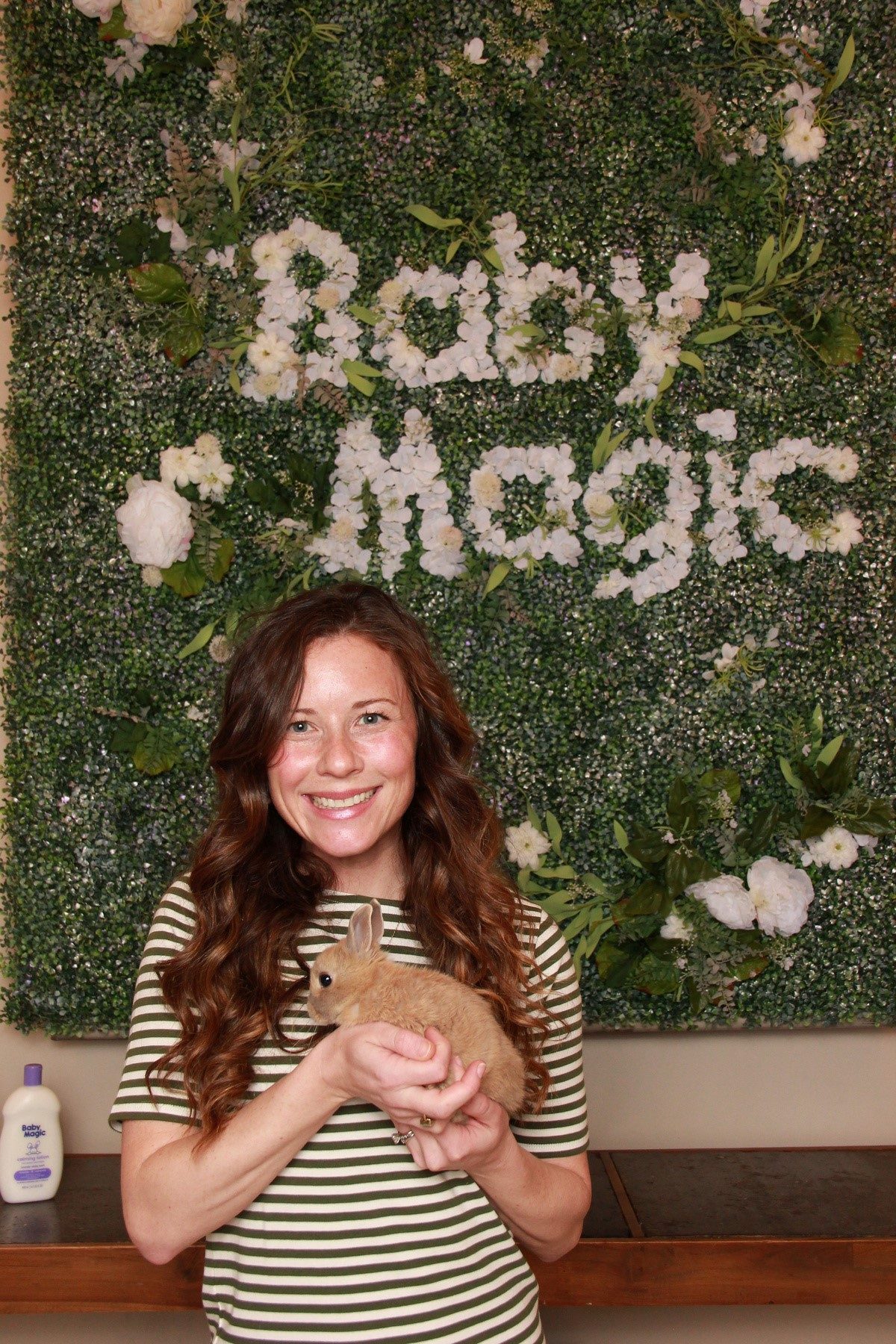 Baby Magic Event Woman wearing green striped shirt holding a baby bunny