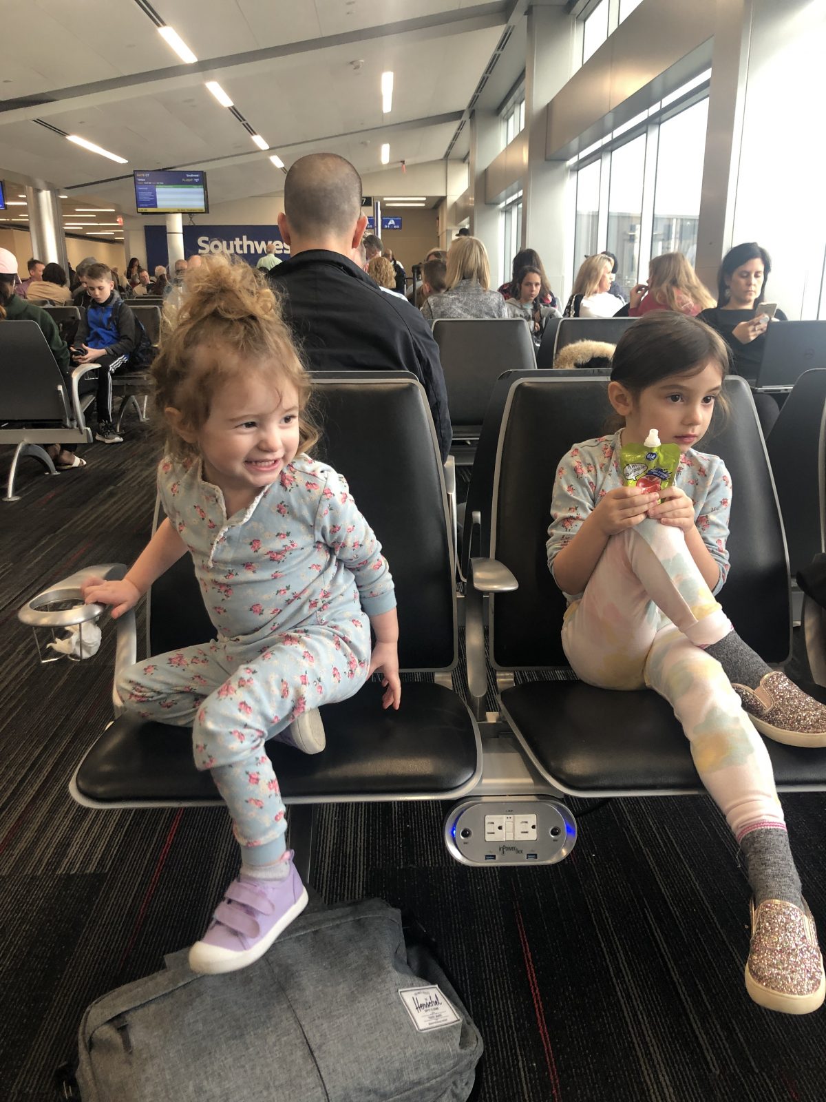 Toddlers waiting to board a plane in seating area