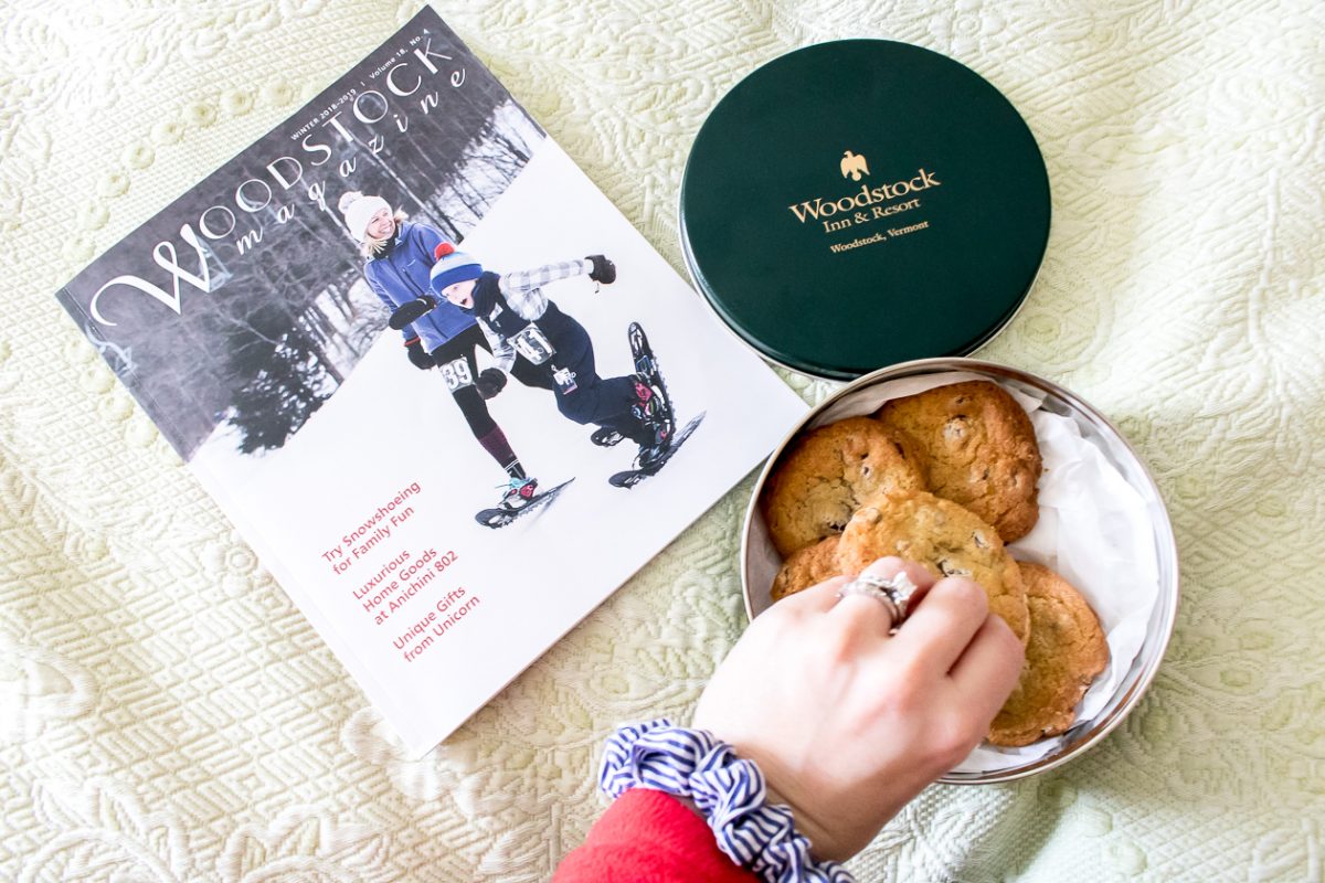 Woodstock Magazine and hand reaching into green tin of chocolate chip cookies