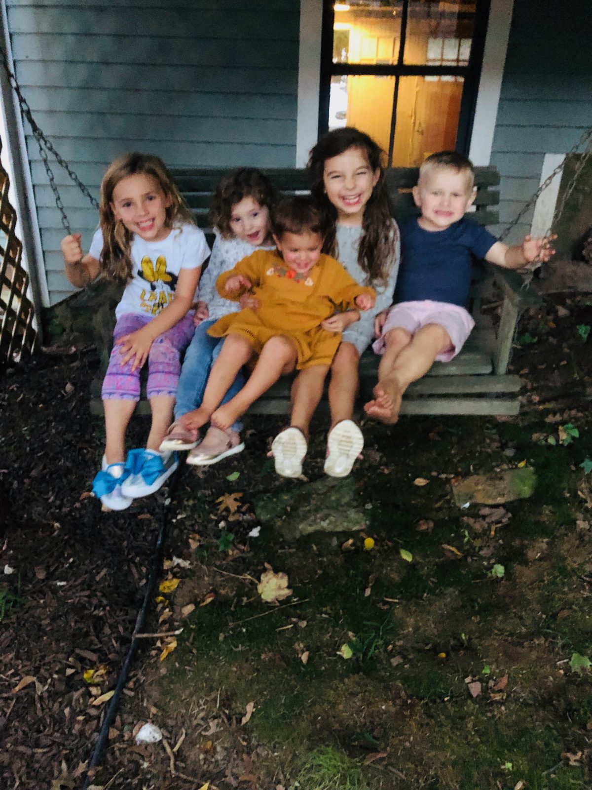 kids laughing on a porch swing