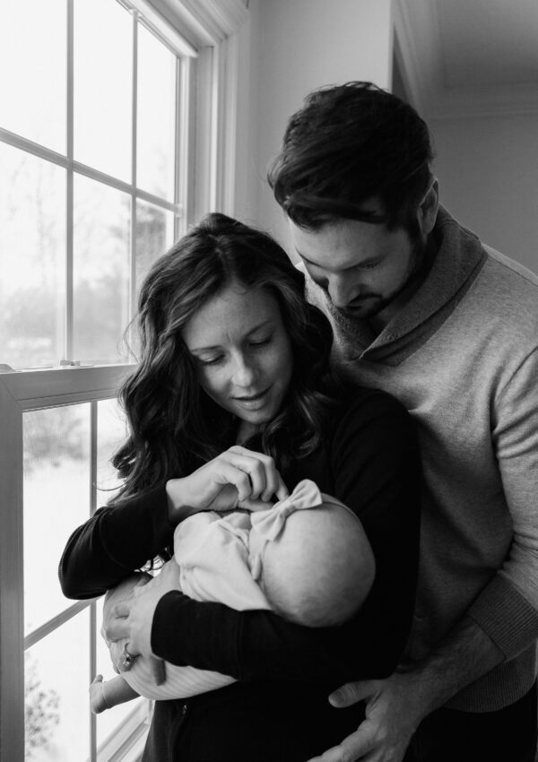 new parents looking at newborn black and white photo