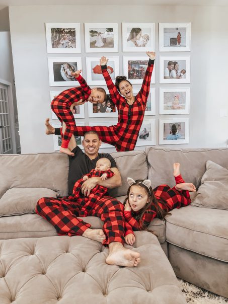 Family Being Silly Wearing Matching Christmas Pajamas