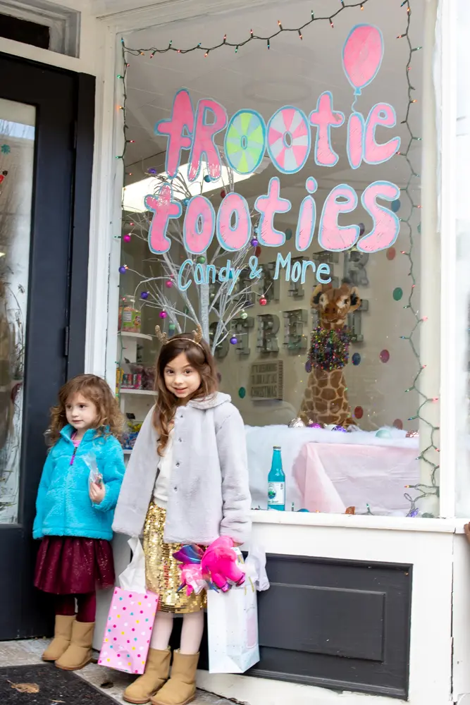little girls standing outside frootie tooties candy store