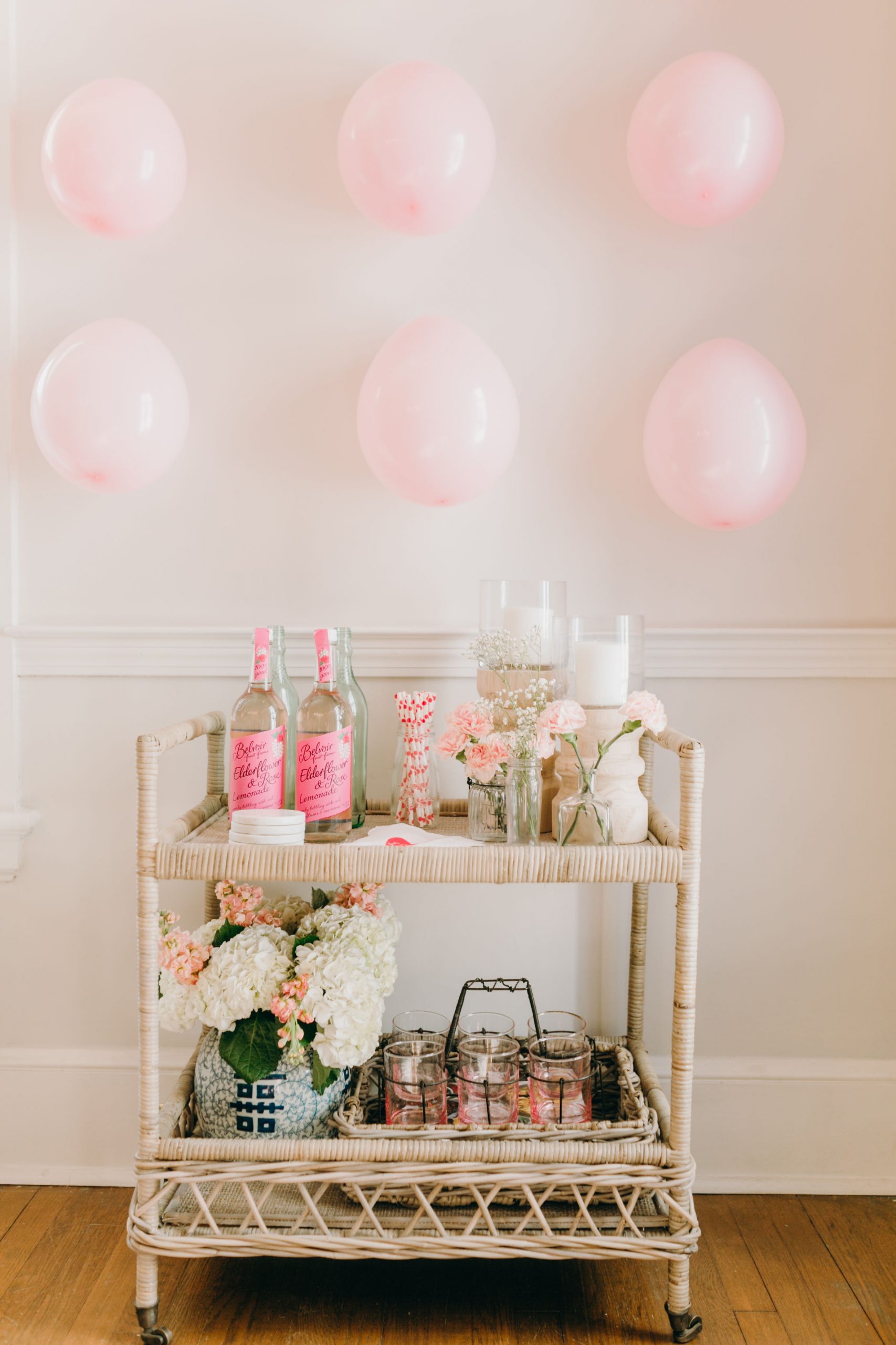 rattan bar cart decorated for valentine's theme pink balloon wall