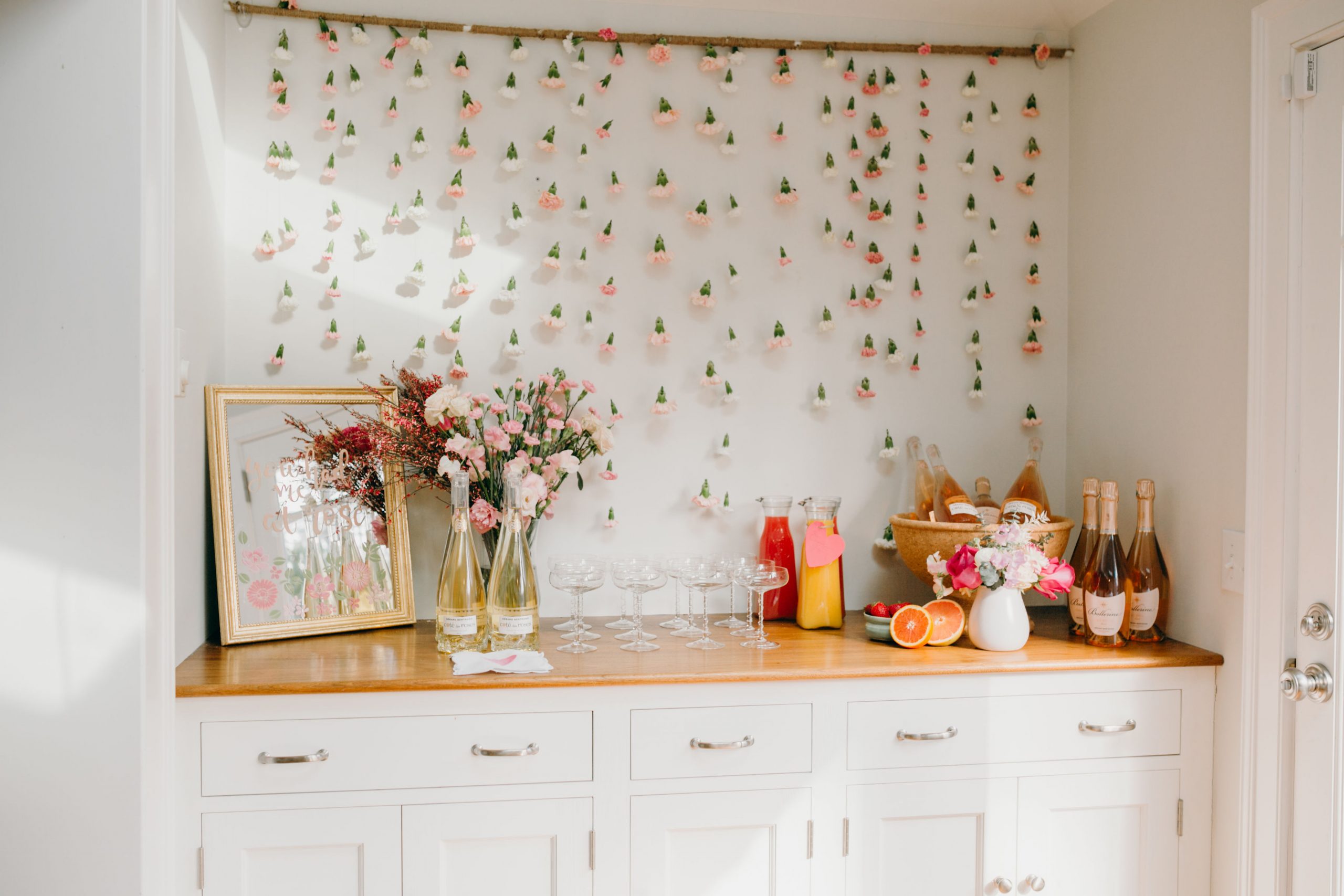 floral wall behind build in bar at home stocked for galentine's day brunch