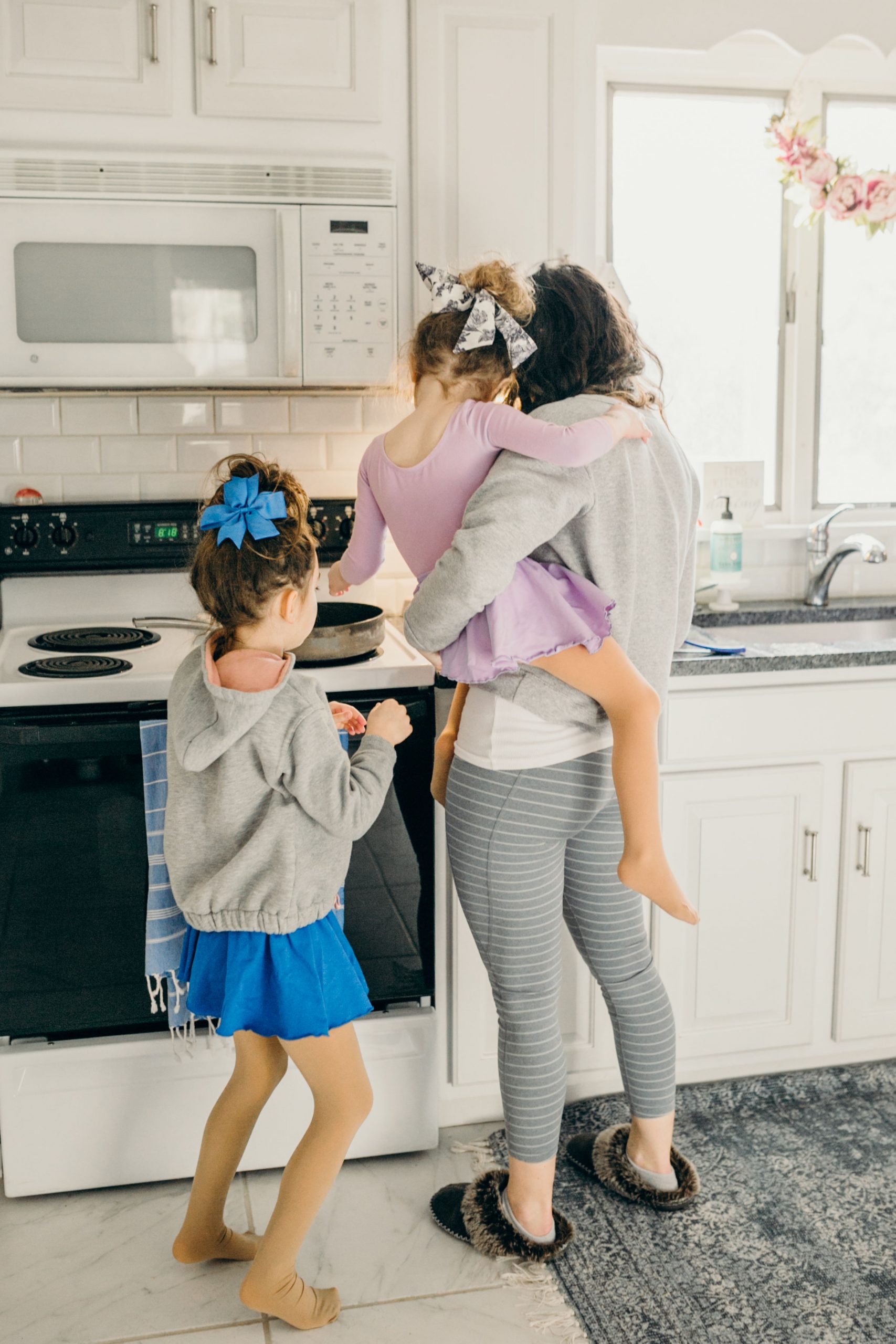 Mom holding daughter cooking in kitchen