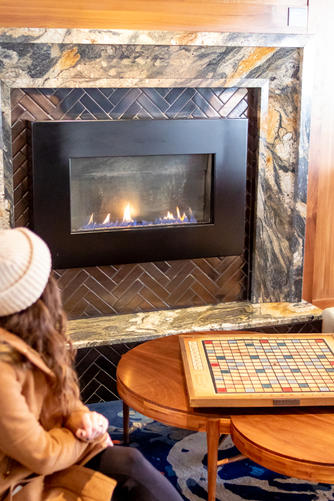 Woman sitting in the Press Hotel Lobby by the fireplace