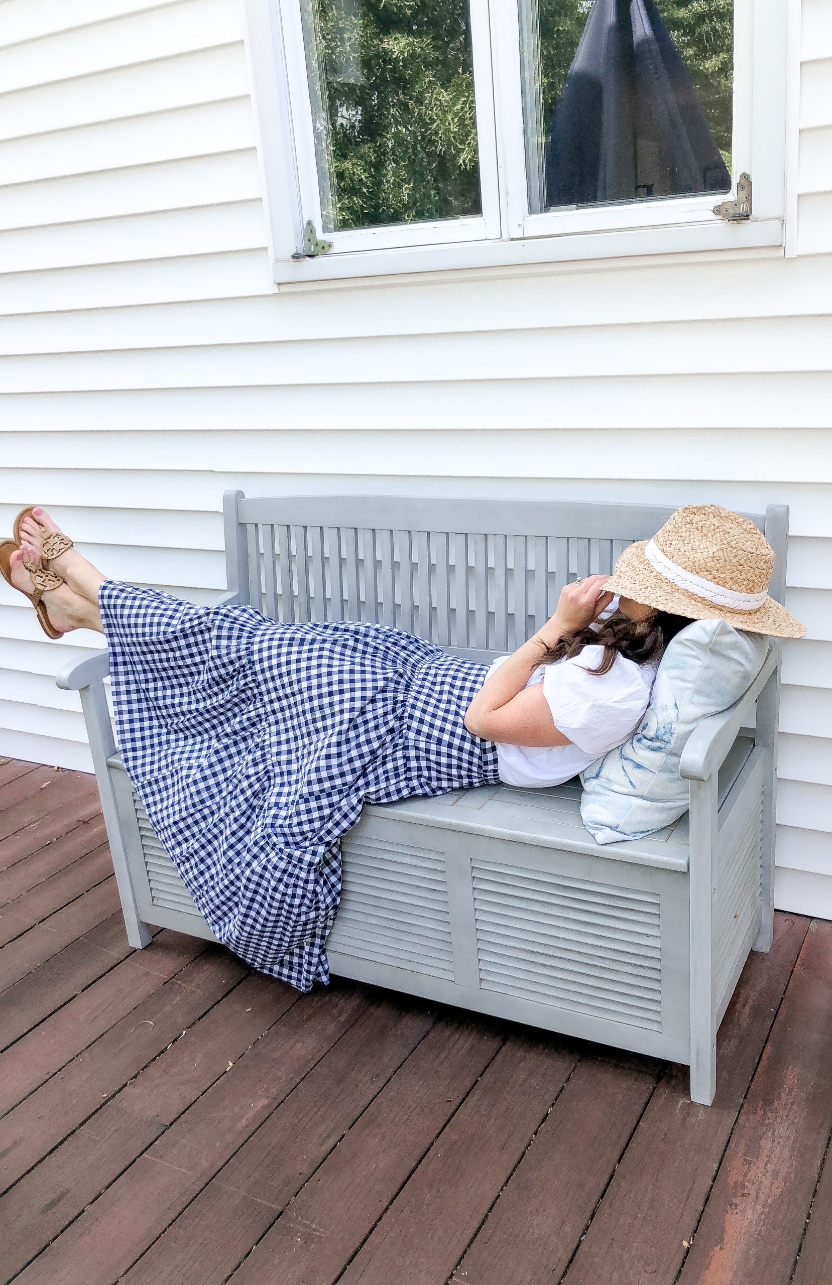 woman on a blue deck bench with blue pillow