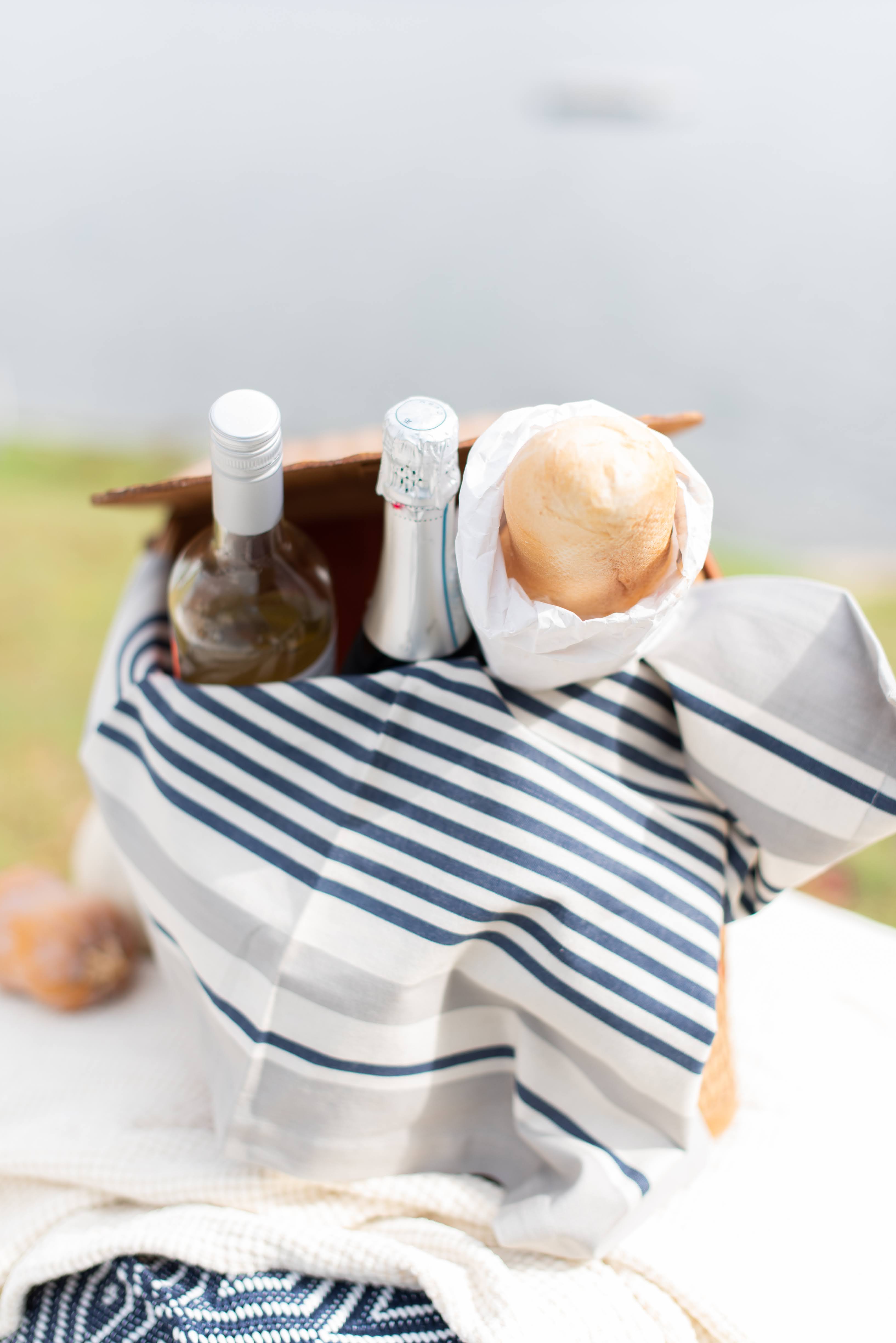picnic basket with wine and bread gunner stripe napkin by annie selke
