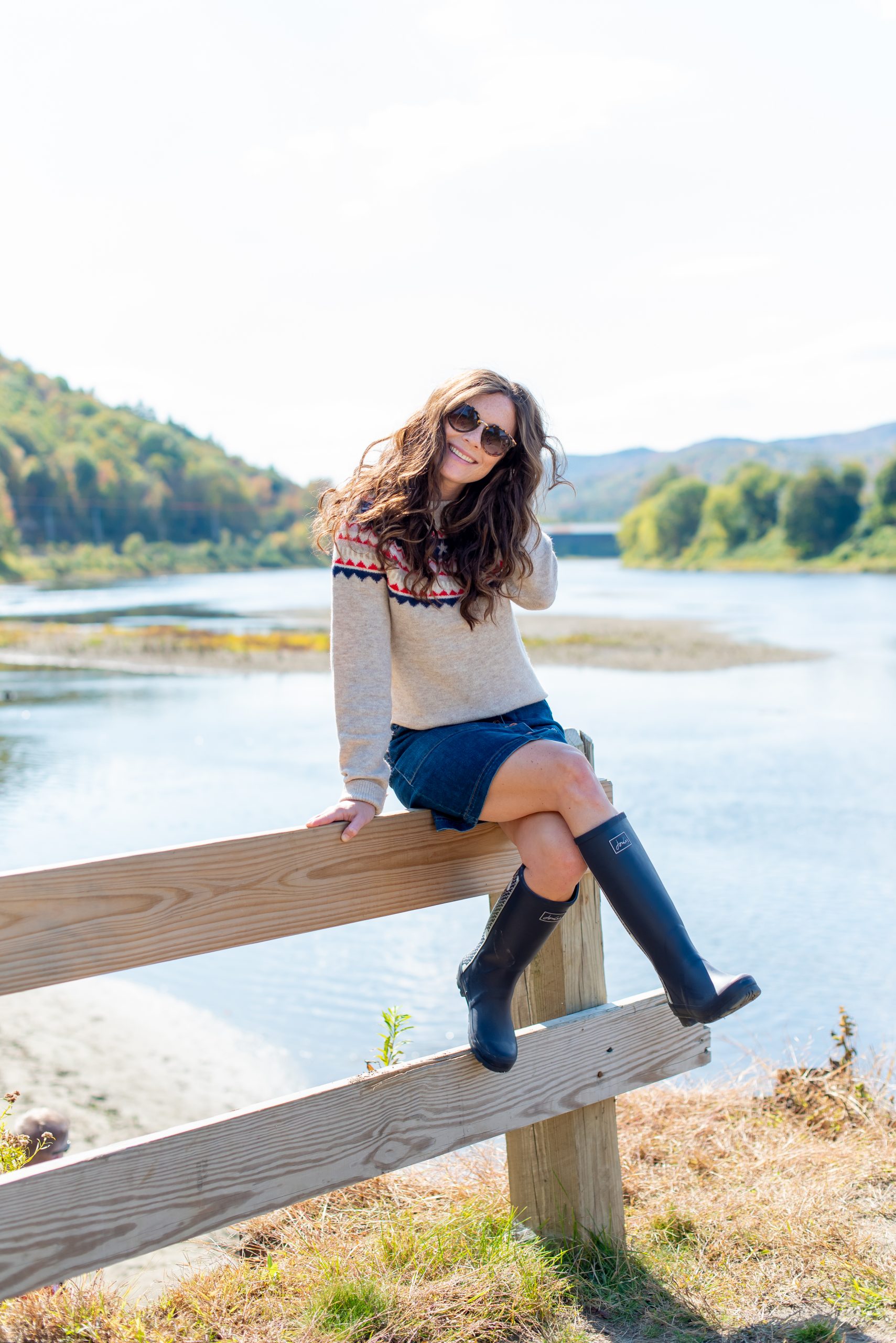 Girl wearing preppy New England fall outfit fairisle sweater and denim skit in Vermont 