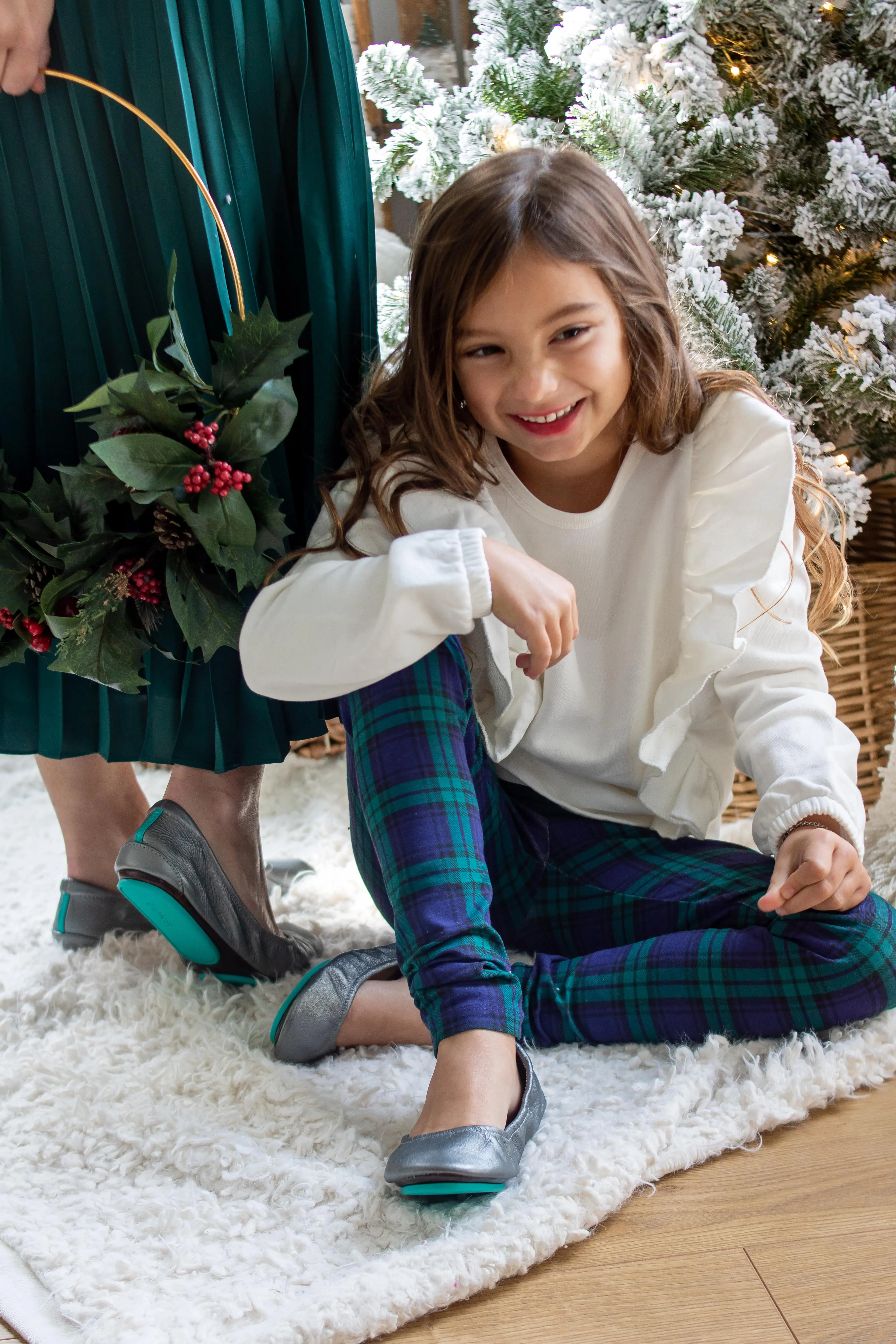 little girl in white sweatshirt plaid pants with little miss tieks holiday outfit