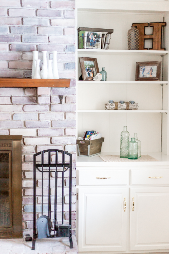 whitewash brick fireplace and white built in shelves