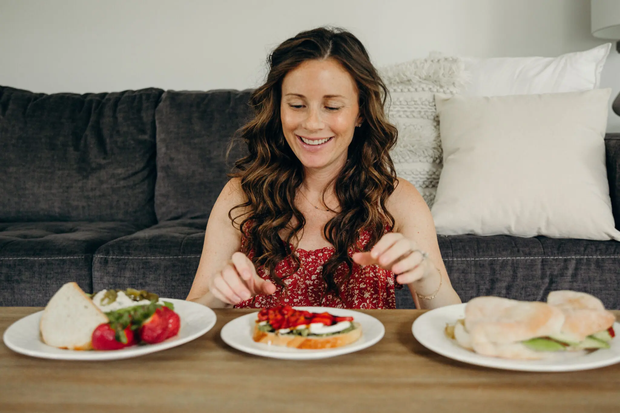  Sandwiches to Eat While Pregnant - Caitlin Houston sits in front of three sandwiches to eat while pregnant