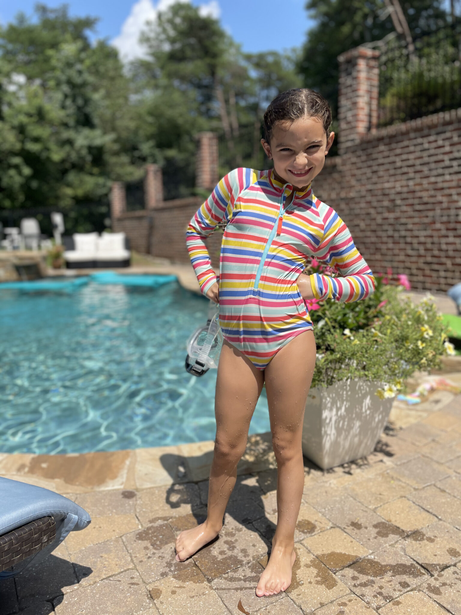 little girl in swimsuit by pool