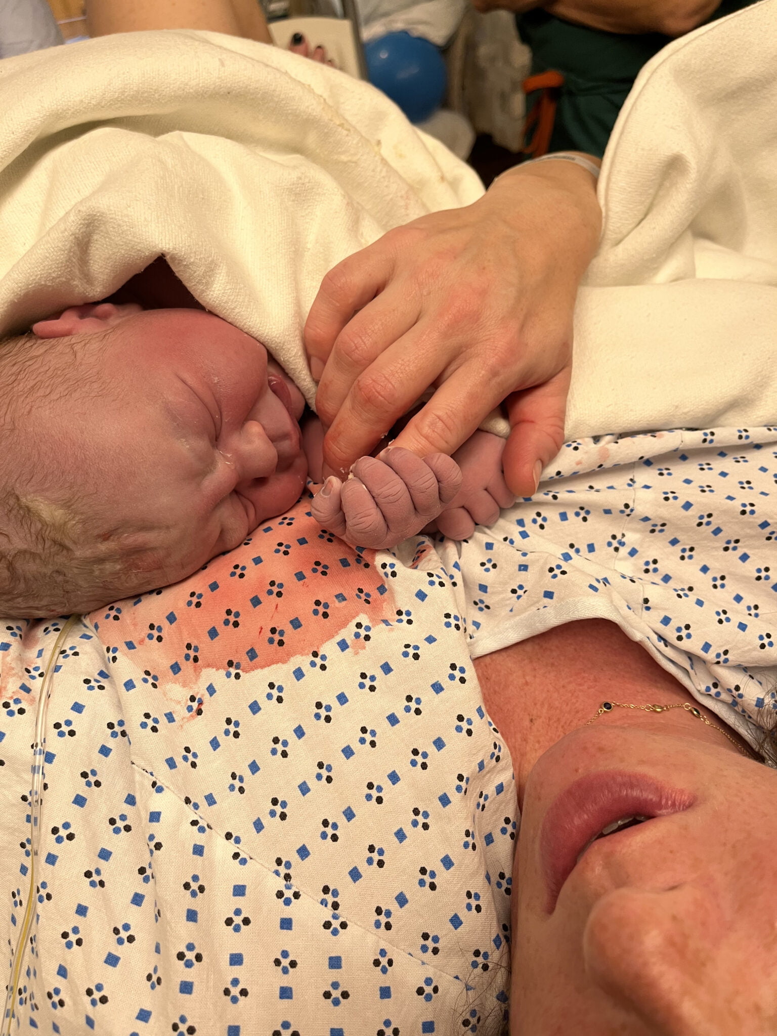 newborn baby holding Moms hand