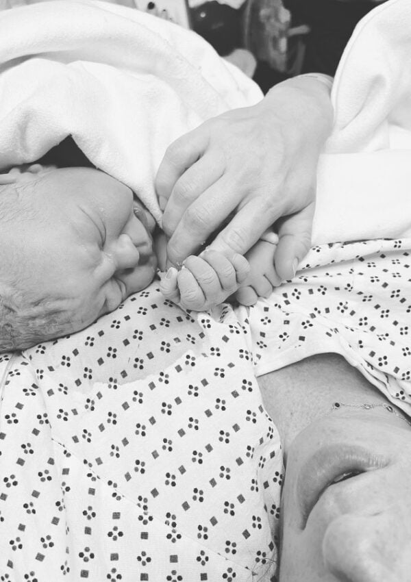 newborn holding moms finger
