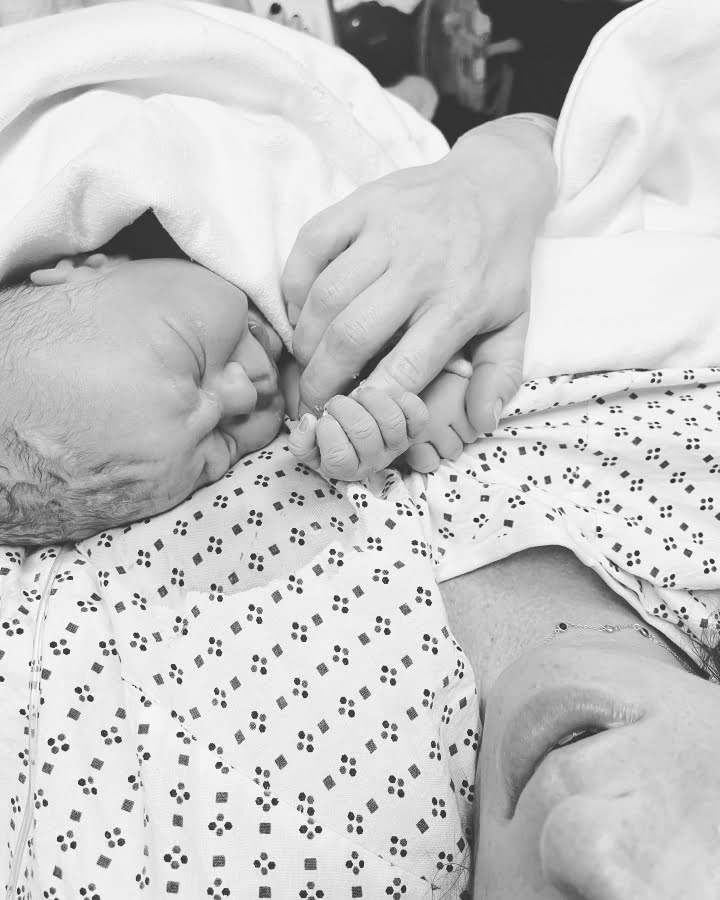 newborn holding moms finger
