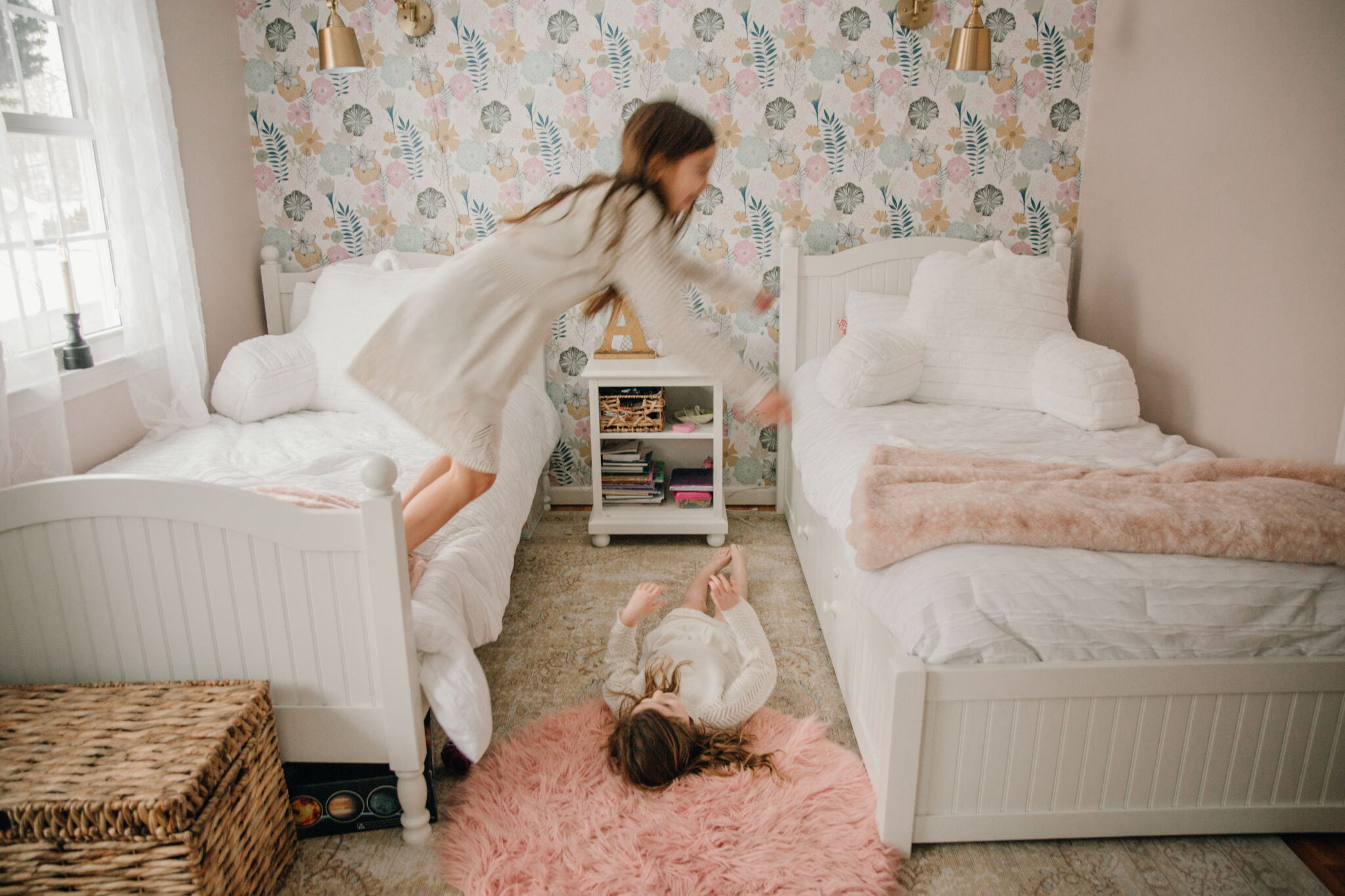 girls jumping on beds in shared bedroom