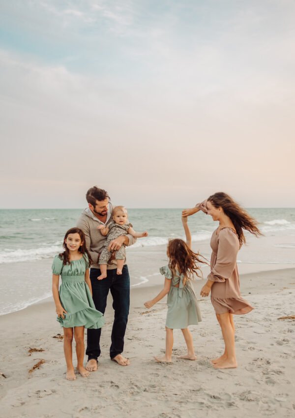 Fall family photo on beach green and tan outfits