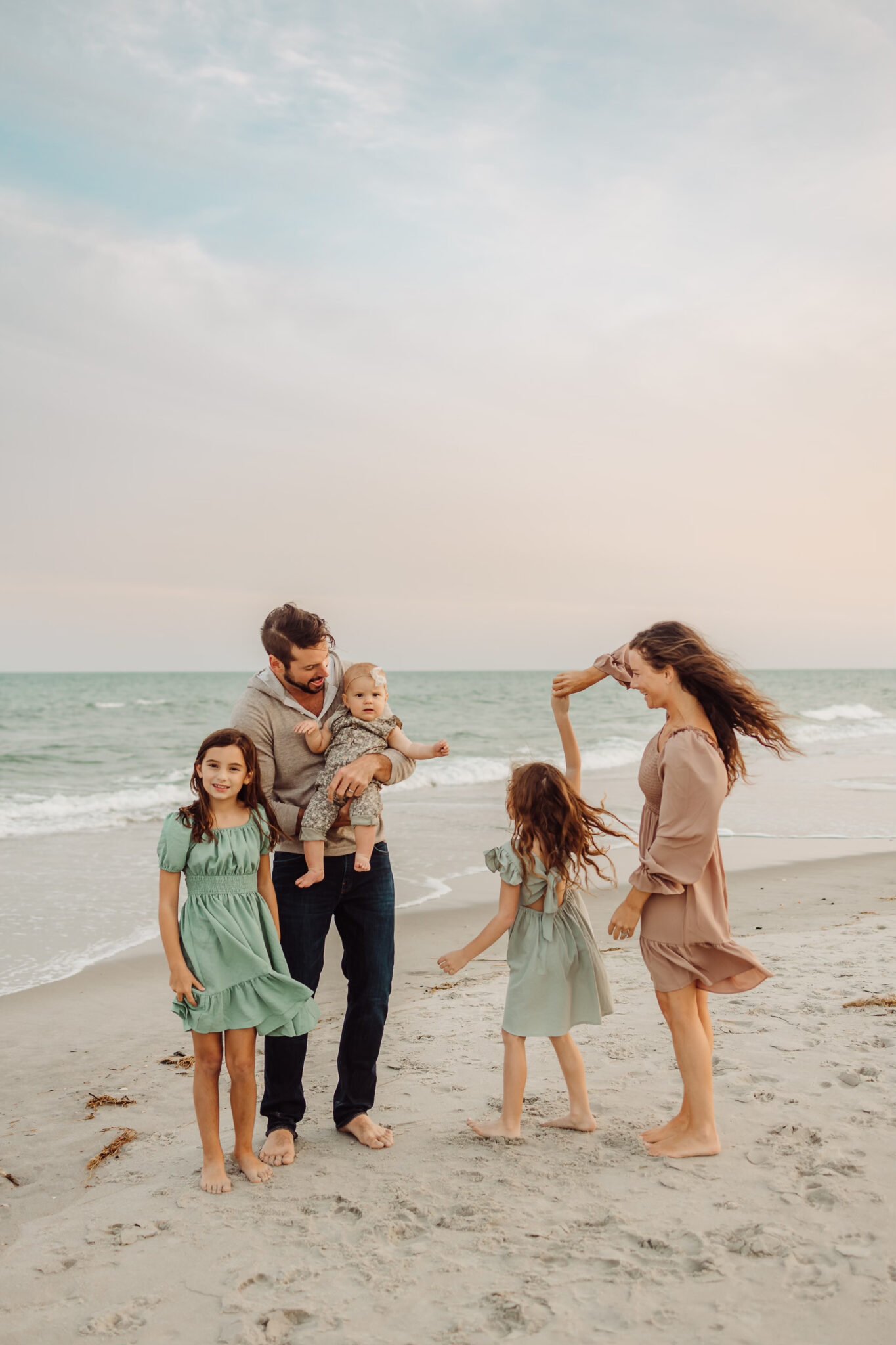 Fall family photo on beach green and tan outfits