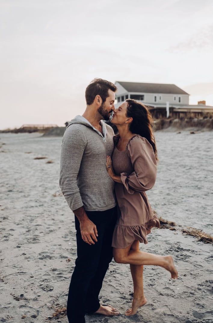 couple kissing on beach anniversary photos brown and gray colors