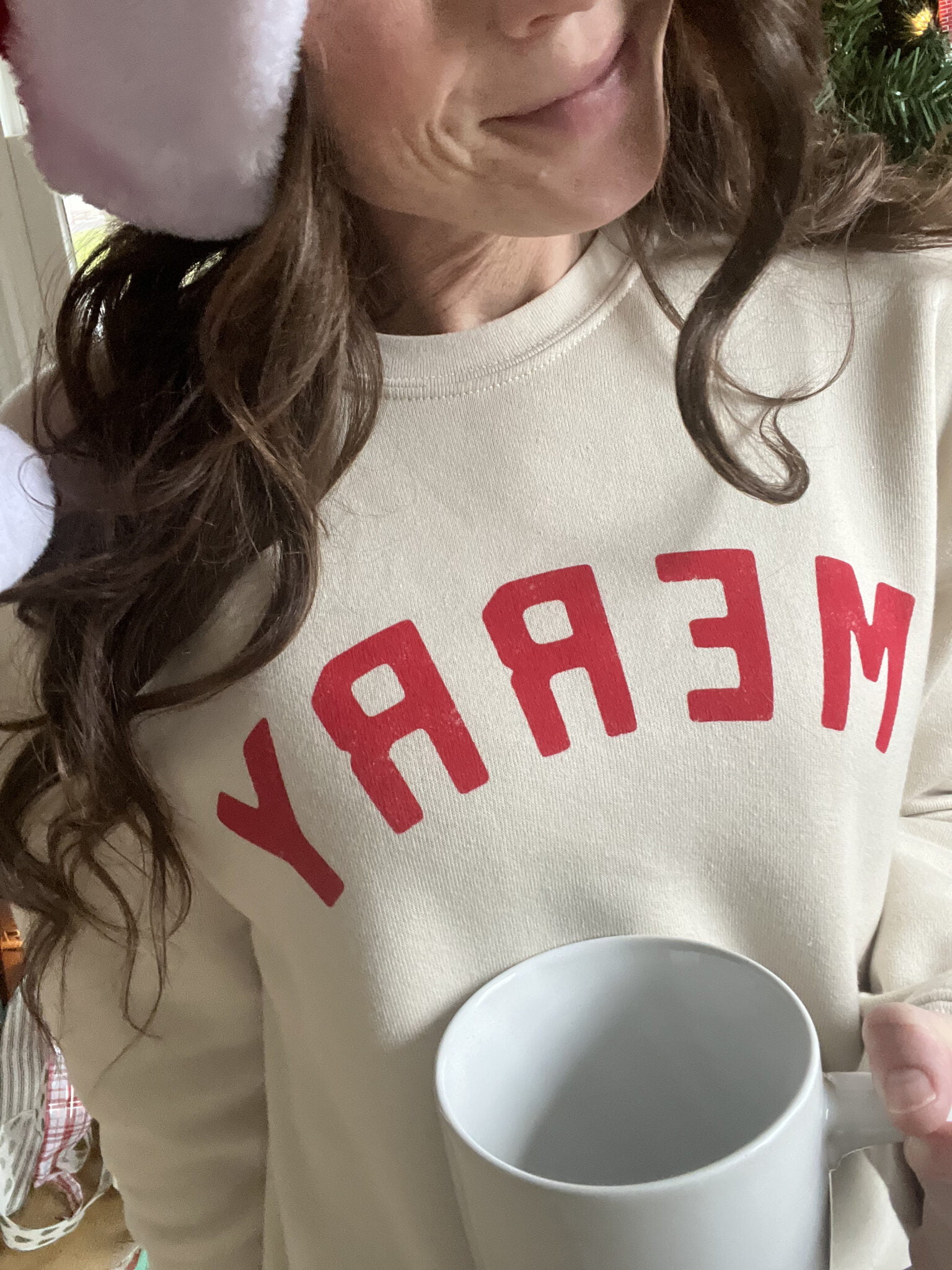 woman in merry sweatshirt with cup of coffee