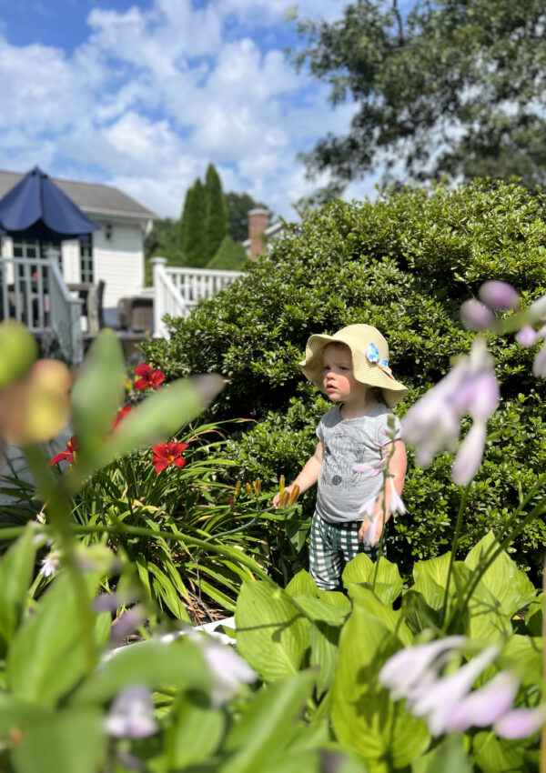 Toddler wearing sun hat standing in garden Life Lately July 2023 Caitlin Houston Blog