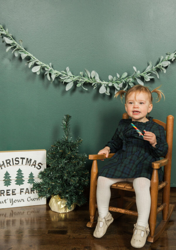 Toddler with candy cane in rocking chair for 2nd birthday