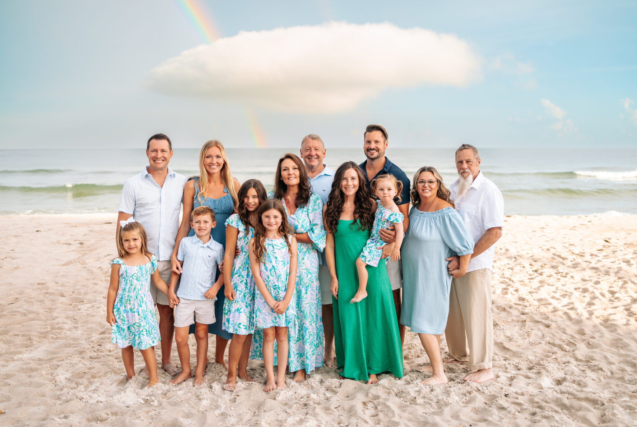 beach family photos in green and blue outfits posed