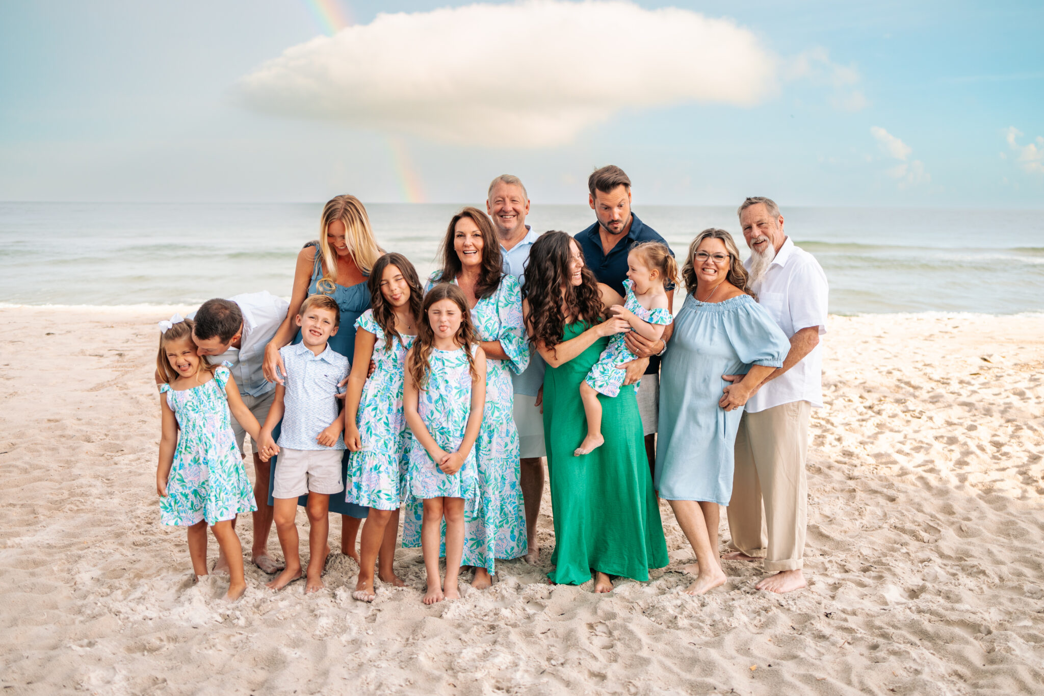 beach family photos in green and blue outfits candid