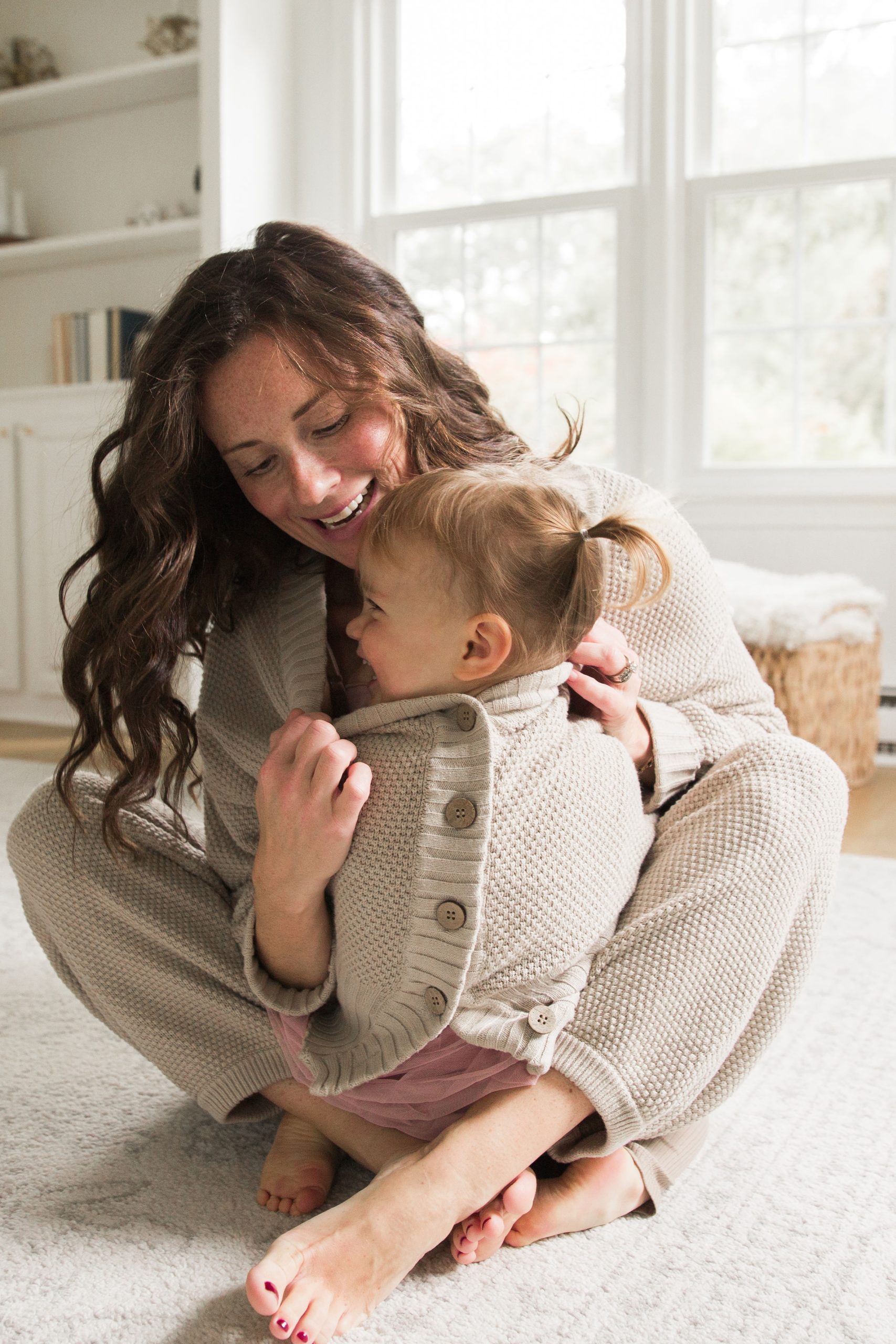 overstimulated mom with toddler inside her sweater