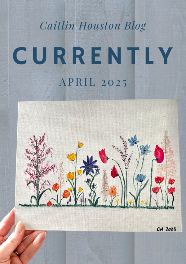 Hand holding painted watercolor wildflower canvas in front of wall