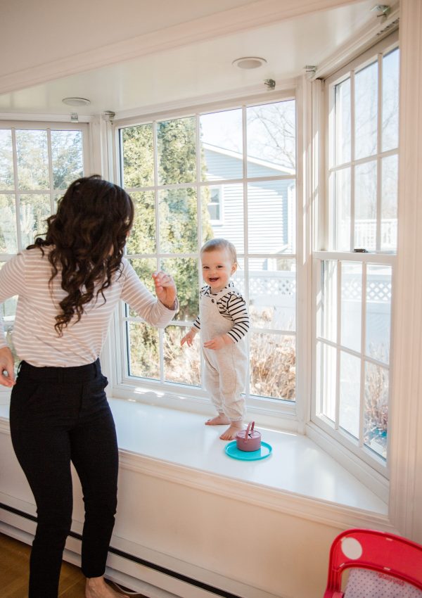 Mom dancing with one year old in window with birthday gift ideas