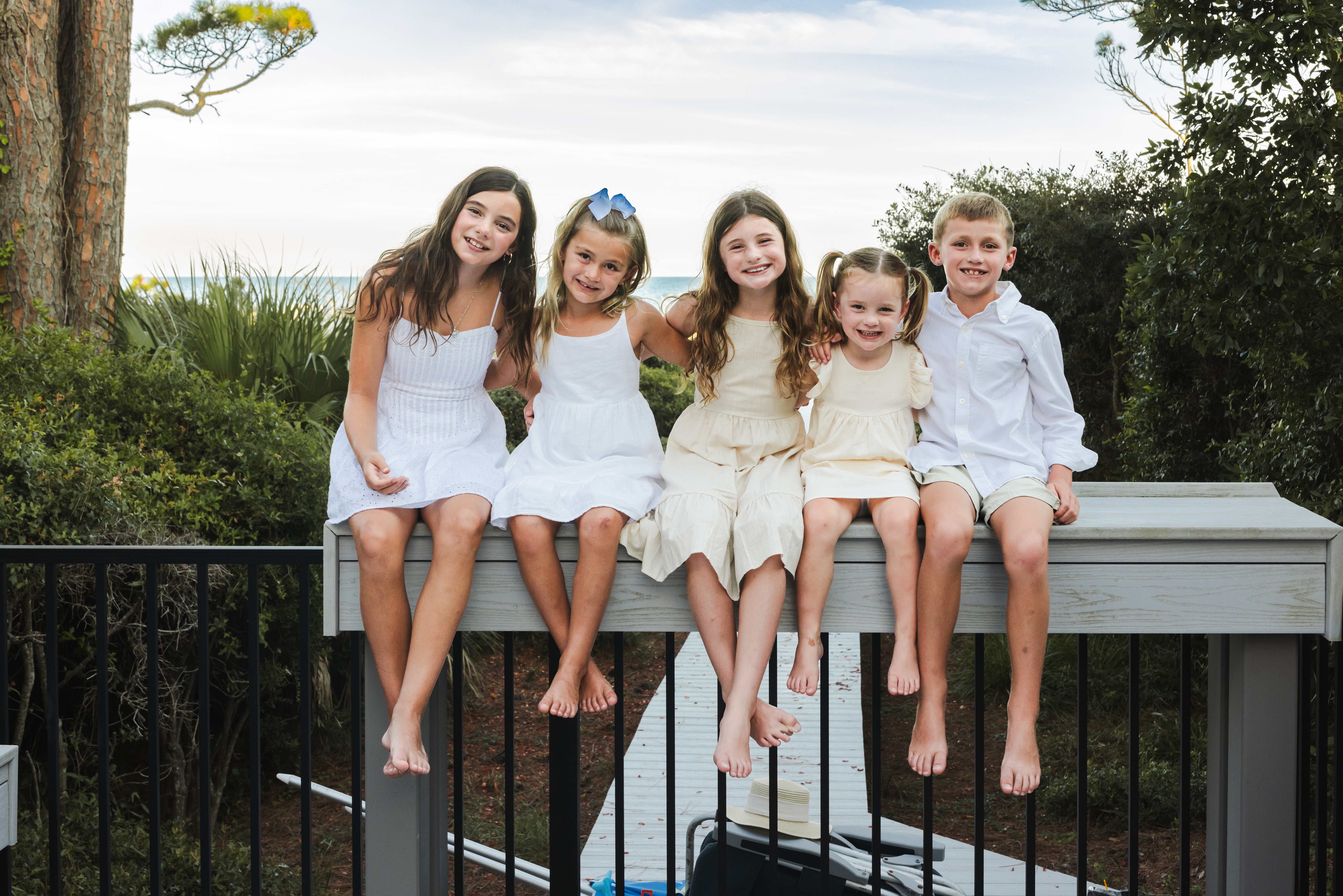 kids sitting on ocean view railing Hilton Head professional family photos Camera Koala
